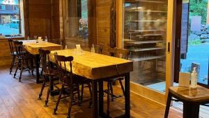 a row of wooden tables and chairs in a restaurant at irodori in Matsumoto