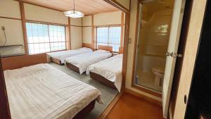 a hospital room with three beds and a toilet at irodori in Matsumoto