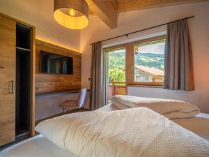 a bedroom with a bed and a large window at Chalet Bodahof in Aschau