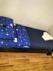 a bed with a blue comforter and pillows at L'incanto home in Bologna