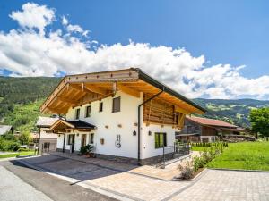 a white building with a wooden roof at Chalet Bodahof in Aschau