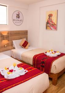 a hotel room with two beds with plates on them at Runas Inn Machupicchu in Machu Picchu