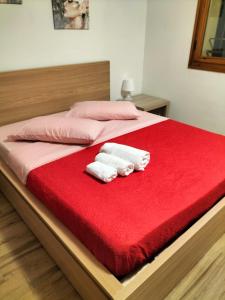 a bed with two towels on a red blanket at L'incanto home in Bologna