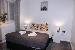 a bedroom with a bed with two towels on it at Dartford Kent House - Hosted by Castile Accommodations Ltd in Kent