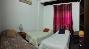 une petite chambre avec deux lits et une fenêtre dans l'établissement Departamento Iguazú Cataratas, à Puerto Iguazú 23 autres photos