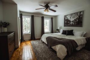 a bedroom with a bed and a ceiling fan at Modern 4 season cottage retreat in Huntsville