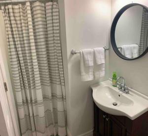 a bathroom with a shower curtain and a sink at Modern 4 season cottage retreat in Huntsville