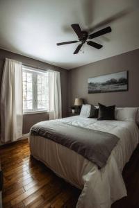 a bedroom with a bed with a ceiling fan at Modern 4 season cottage retreat in Huntsville