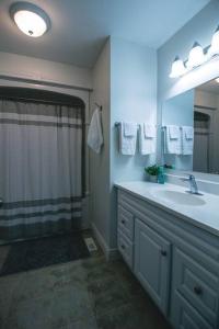 a bathroom with a shower and a sink and a mirror at Modern 4 season cottage retreat in Huntsville