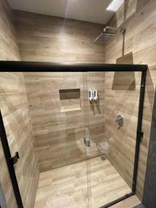 a shower with a glass door in a bathroom at River Paradise Villa in Fortuna