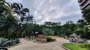 a person standing in a park with a playground at Flat confortável próximo a praia! in Rio de Janeiro