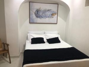 un letto bianco con due cuscini sopra di TURISHOUSE SUITES a Salvador