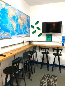 a classroom with chairs and a desk with a world map on the wall at Vilarejo Hostel Pinheiros Guest House in Sao Paulo