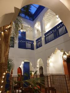 an archway in a building with tables and chairs at Riad Dar Colline in Marrakesh