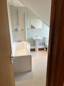 baño blanco con ducha y lavamanos en The Jagdamer Lodge, 