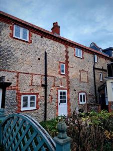 un edificio di mattoni con un cancello di fronte di The Wave - 3 bed beach front home in Sheringham a Sheringham