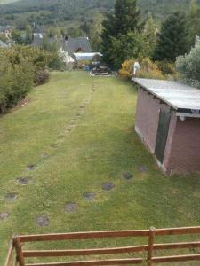 an empty yard with a building in the grass at Catedral view mínimo 4 noches in San Carlos de Bariloche