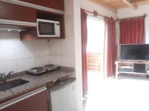 a small kitchen with a sink and a microwave at Catedral view mínimo 4 noches in San Carlos de Bariloche