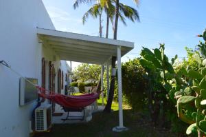 a hammock hanging from a porch of a house at Two Palms Apartment - in Sweet Jewel Apartments in Christ Church