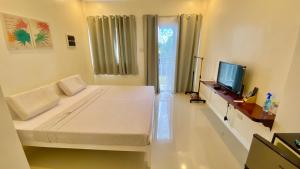a bedroom with a large bed and a television at Villa del OZ Resort in Panglao Island