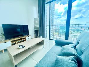 a living room with a blue couch and a large window at F 1-5 Pax 3bed Cozy Home Studio Trefoil Setia Alam WIFI & TV in Shah Alam