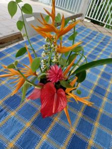 un jarrón lleno de flores en una mesa en Maison chaleureuse avec terrasse et parking privé, en Le Lamentin