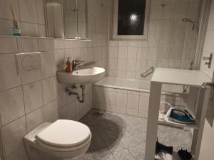 a bathroom with a toilet and a sink and a tub at 3 Zimmer Apartment nahe Science Park und Ulm City Center in Ulm