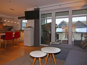 a living room with a couch and tables and a kitchen at Holiday Home Sturmeck, Fehmarn-Orth in Orth