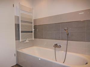 a bath tub with a shower in a bathroom at Holiday Home Sturmeck, Fehmarn-Orth in Orth