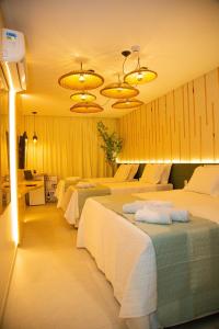 una habitación de hotel con 3 camas en una habitación en Pousada Águas de Maragogi en Maragogi