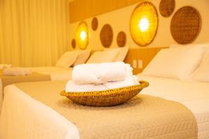 馬拉戈日的住宿－Pousada Águas de Maragogi，在酒店客房内的床上放置一篮毛巾