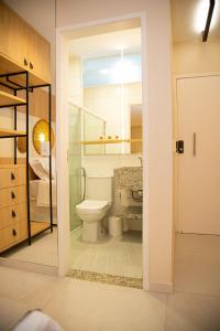 a bathroom with a toilet and a glass door at Pousada Águas de Maragogi in Maragogi