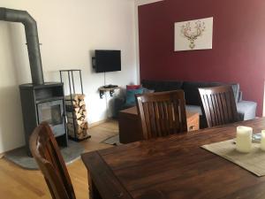 sala de estar con mesa y estufa de leña en Ferienwohnung Landhaus zum Sonnenschein en Marquartstein