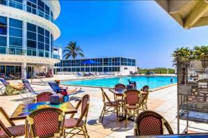 uma piscina com cadeiras e mesas e um edifício em 7th - 7 Heaven Miami - Stunning Ocean View - Free Parking em Miami Beach