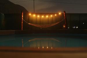 una valla con luces y una piscina por la noche en Cabaña Alpina SEAL, en Oxapampa