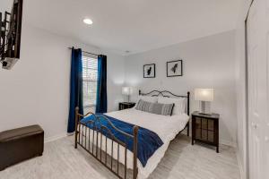 a white bedroom with a bed and a window at Welcome to Villa Azul, your home away from home! in Kissimmee +16 photos