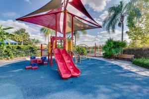 a playground with a slide and an umbrella at Welcome to Villa Azul, your home away from home! in Kissimmee