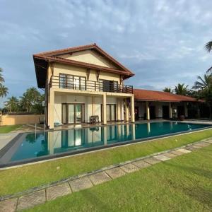 a house with a swimming pool in front of it at Reef Bungalow Private Villa, 6 bedrooms in Bopitiya