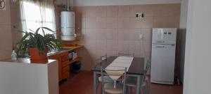 a kitchen with a table and a white refrigerator at Cabaña Aike in El Calafate