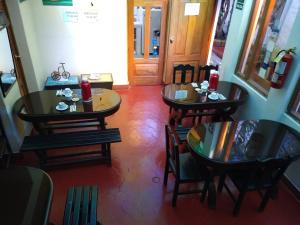 a restaurant with three tables and chairs and a door at Casa de Mama Cusco 2-The Ecohouse in Cusco