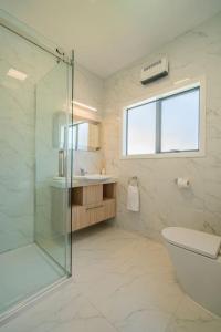 a bathroom with a shower and a toilet and a sink at On the Point in Whitianga