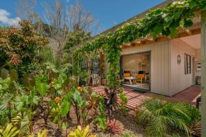a home with a patio and a garden at On the Point in Whitianga