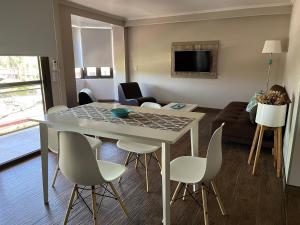 - un salon avec une table et des chaises blanches dans l'établissement Perito Moreno - 3ro A, à Puerto Iguazú