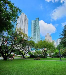 a park with trees and buildings in a city at Modern Hotel-type Studio near Greenbelt Netflix 100mbps in Manila