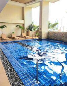 a large swimming pool in a hotel lobby at Modern Hotel-type Studio near Greenbelt Netflix 100mbps in Manila