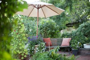 a bench with an umbrella in a garden at 10 Clarke in Frederick