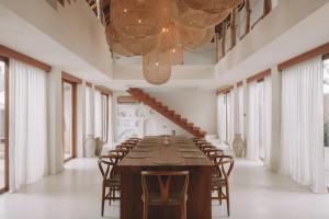 a long dining room with a long table and chairs at Belajar Bali Boutique Hotel and Retreat in Canggu