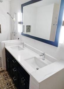 bagno con lavandino bianco e grande specchio di Hannie's Gasthuis a Blind Bay Altre 26 foto