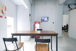 a table and chairs in a room with a motorcycle at Urbanview Hotel Syariah De Umbrella Ciputat in Tangerang