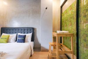 丹格朗的住宿－Urbanview Hotel Syariah De Umbrella Ciputat，一间卧室配有一张床和一张带镜子的桌子